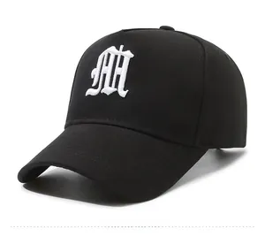 Close-up of gothic white embroidered M on high crown black cotton baseball cap