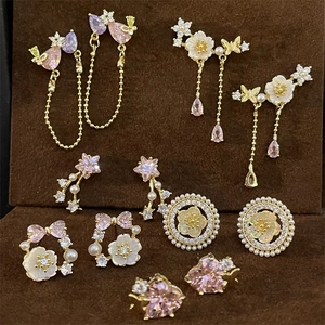 Elegant vintage gold earrings set with pink crystals and pearls on velvet display
