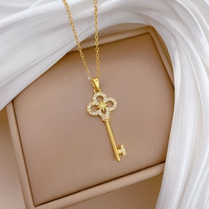 Macro shot of gold starburst cross key pendant with crystals on silk and leather