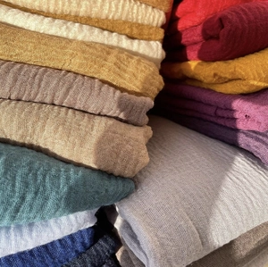 Stack of colorful crinkle cotton scarves with rich vertical texture and soft muslin fabric
