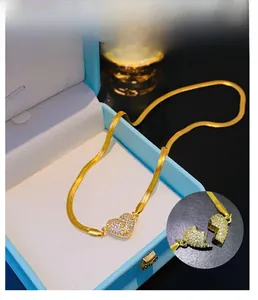 Detail of magnetic heart pendant with sparkling crystals on gold snake chain necklace