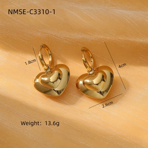 Polished 18K gold-plated stainless steel heart drop earrings on yellow silk backdrop