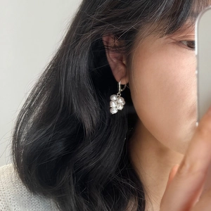Close-up of natural freshwater pearl cluster earrings in silver on model's ear