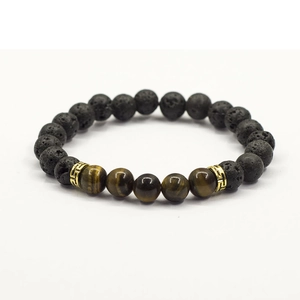 Close-up view of beaded bracelet featuring black lava stone and natural tiger eye stones with gold spacers.
