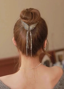 Rear view of a wing-shaped hair claw clip with crystal tassels worn on a bun hairstyle