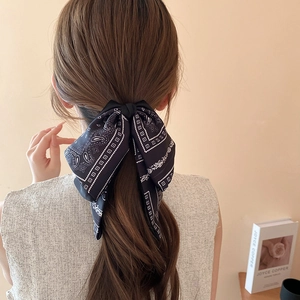 Elegant paisley bow hair clip tied on model back view with chic chiffon texture