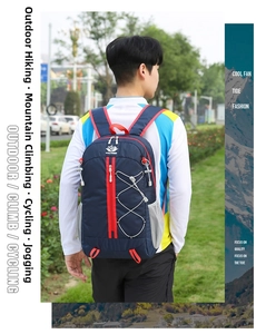 Detail of navy outdoor hiking backpack featuring a red vertical zipper and white bungee cords