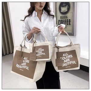 Detailed set of three cream canvas tote bags with brown leather trim in various sizes