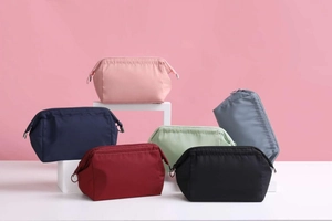 Close-up of waterproof nylon makeup bags in six vibrant colors displayed on pedestals