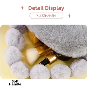 Detail view of large grey plush makeup bag with soft pom-pom handle and interior storage