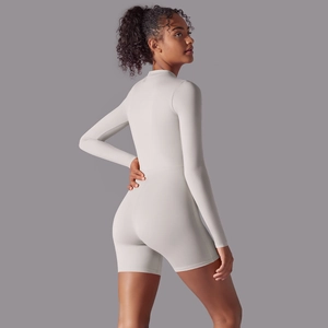 Close-up of seamless light grey long sleeve athletic bodysuit with slim fit shorts
