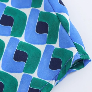 Gros plan sur le tissu à motifs géométriques avec coutures précises en bleu et vert