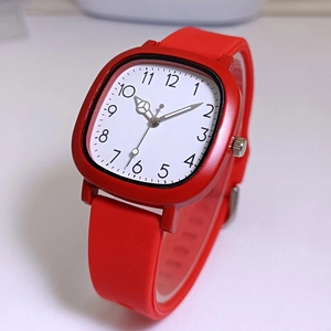 Detail of red square quartz watch featuring a white dial and silicone strap with Arabic numerals