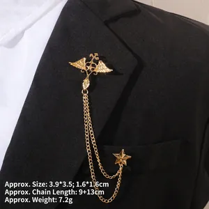 Vue détaillée d'une broche étoile baroque dorée avec chaîne sur revers de veste