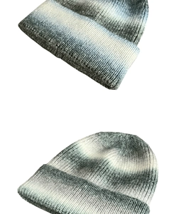 Close-up of grey and white gradient ribbed knit beanie showing soft winter fabric texture