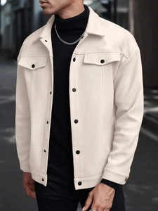 Detail of off-white wool jacket featuring lapel collar, snap buttons, and chest pockets