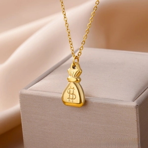 Macro shot of 18k gold dollar sign money bag pendant on elegant silk jewelry display