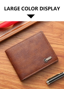 Gros plan du portefeuille en cuir marron pour homme avec logo sur fond de bois