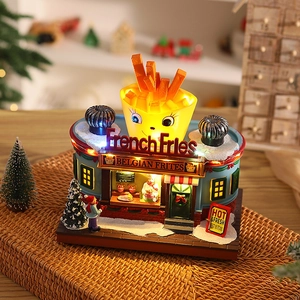 Close-up of glowing French Fries house Christmas ornament with red and blue resin details