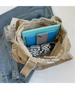 Macro view of khaki canvas tote bag showing large capacity for tablet and umbrella
