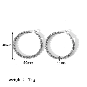Détail de créoles torsadées argentées montrant le diamètre 40mm et le poinçon S925
