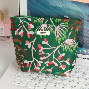 Trousse à maquillage fleurie en toile verte avec motifs de branches et fermeture