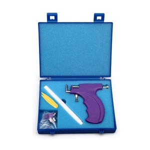 Detailed set of purple ear piercing gun tool with markers and studs in a blue storage box