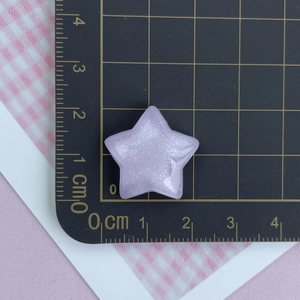 Macro shot of 2.3cm lavender glitter star resin accessory on a measurement grid