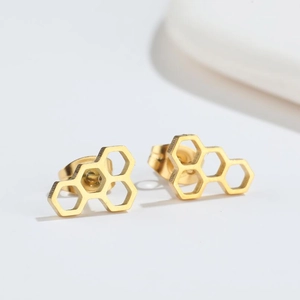 Detail of gold honeycomb stud earrings with irregular hexagon cutout design