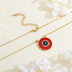 Detail of red evil eye pendant necklace with colorful cubic zirconia and gold-plated chain