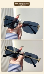 Detailed close-up of gold metal rectangle sunglasses with butterfly hinge decoration
