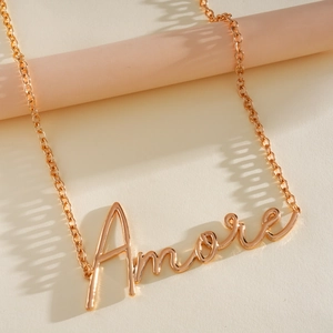 Detailansicht einer goldfarbenen Halskette mit Amore-Schriftzug-Anhänger und eleganter Kette