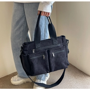 Detail of black corduroy multi-pocket tote bag with dual straps for commuting