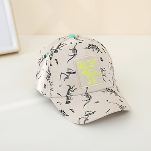 Detail of beige kids baseball cap featuring black dinosaur patterns and a green neon patch