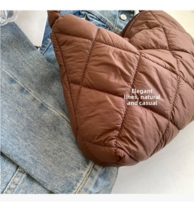 Close-up of dark brown quilted puffer bag showing diamond stitch and glossy fabric