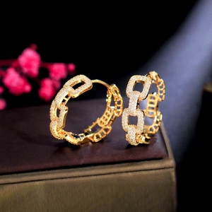Macro view of gold chain hoop earrings featuring sparkling white zircon stone inlay