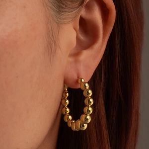 Elegant 18K gold plated beaded hoop earrings for women on model with metallic shine