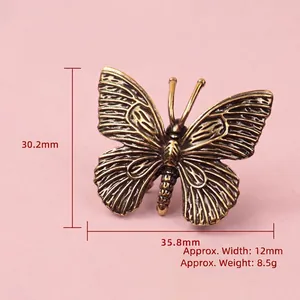 Solid brass butterfly ornament with antique finish showing 30.2mm height and wings detail