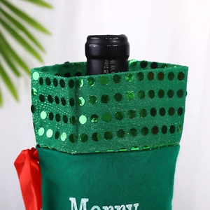 Close-up of green velvet Christmas wine bottle cover with sequins and Merry embroidery