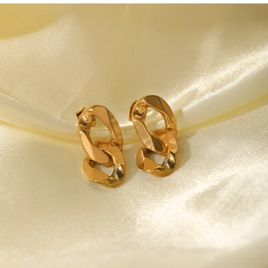 Macro shot of 18K gold plated chain-link drop earrings on luxurious silk background