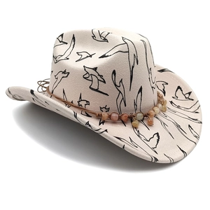 Detail of beige fedora with black bird prints and brown beaded woven hat band decoration