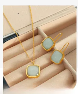 Detail of light green jade jewelry set with gold necklace and earrings in a velvet box