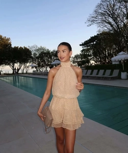 Dettaglio dell'abito beige a pois con scollo all'americana e borsa trapuntata a bordo piscina