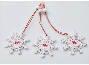 Detailed view of three white wooden snowflake ornaments with red stitched patterns and beads