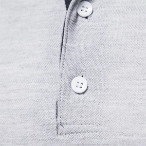 Macro de la texture en piqué du polo gris clair et des boutons en résine blanche