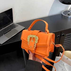 Vibrant orange patent leather handbag with ornate golden Baroque buckle and shoulder strap
