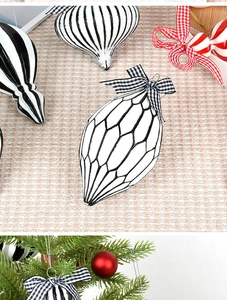 Macro view of black and white geometric Christmas ornaments with checkered ribbons