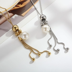 Eleganti collane in oro e argento con perle e nappine su sfondo bianco moderno