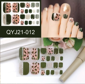 Detail of green and leopard print toe nail stickers with gold foil and glitter finish