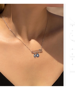 Detail showing S925 silver paperclip necklace with blue Hamsa Hand and Evil Eye charms